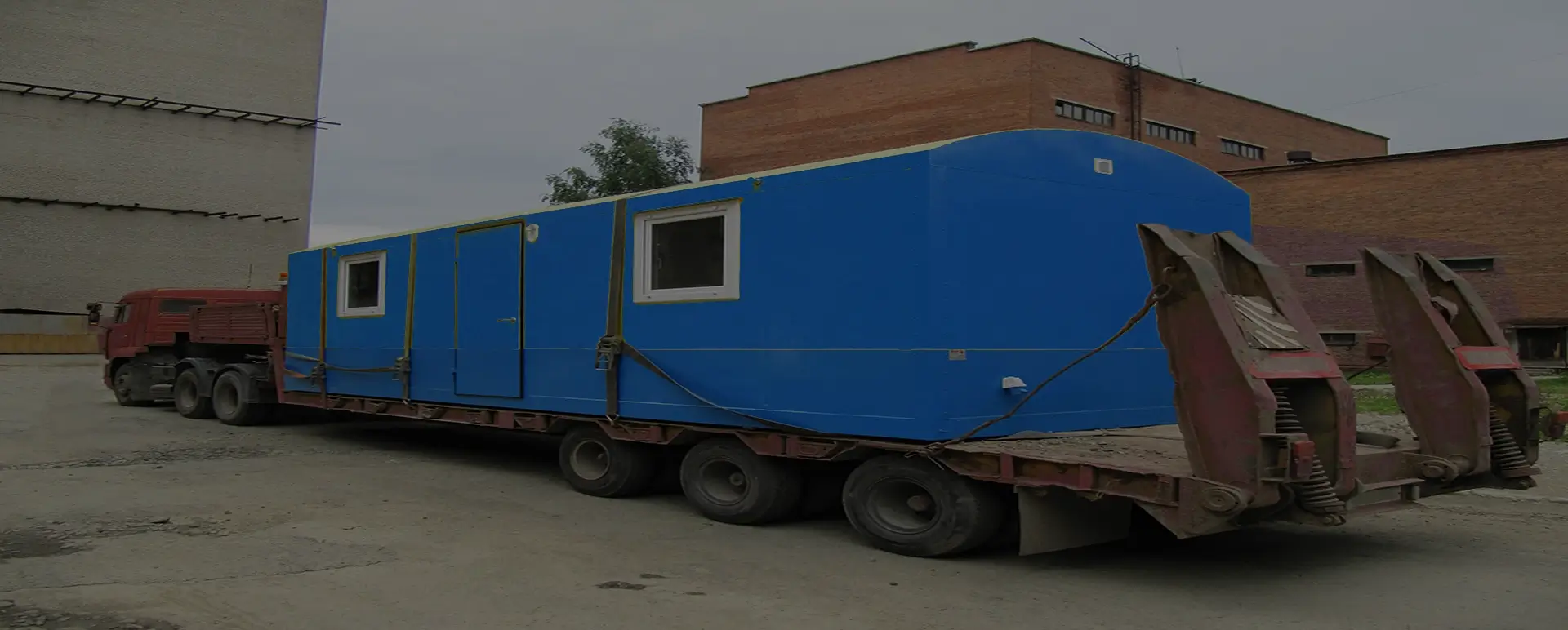 Заказать безопасную и качественную перевозку вагон домов и блок комнат по России из Саков специализированными низкорамными тралами